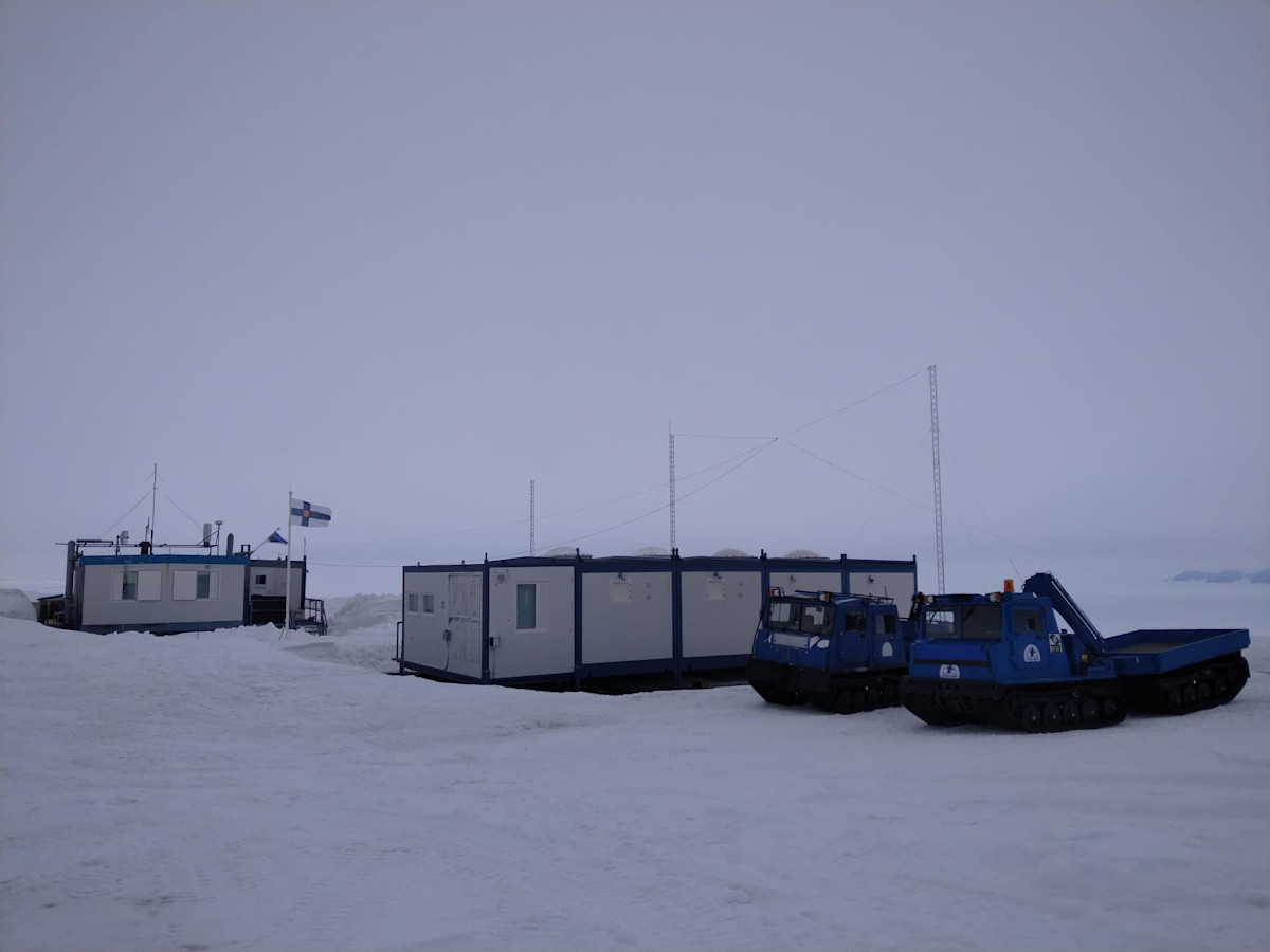 Tutkimusasema Aboa ja nasutelakuorma-autot pilvisenä päivänä. 