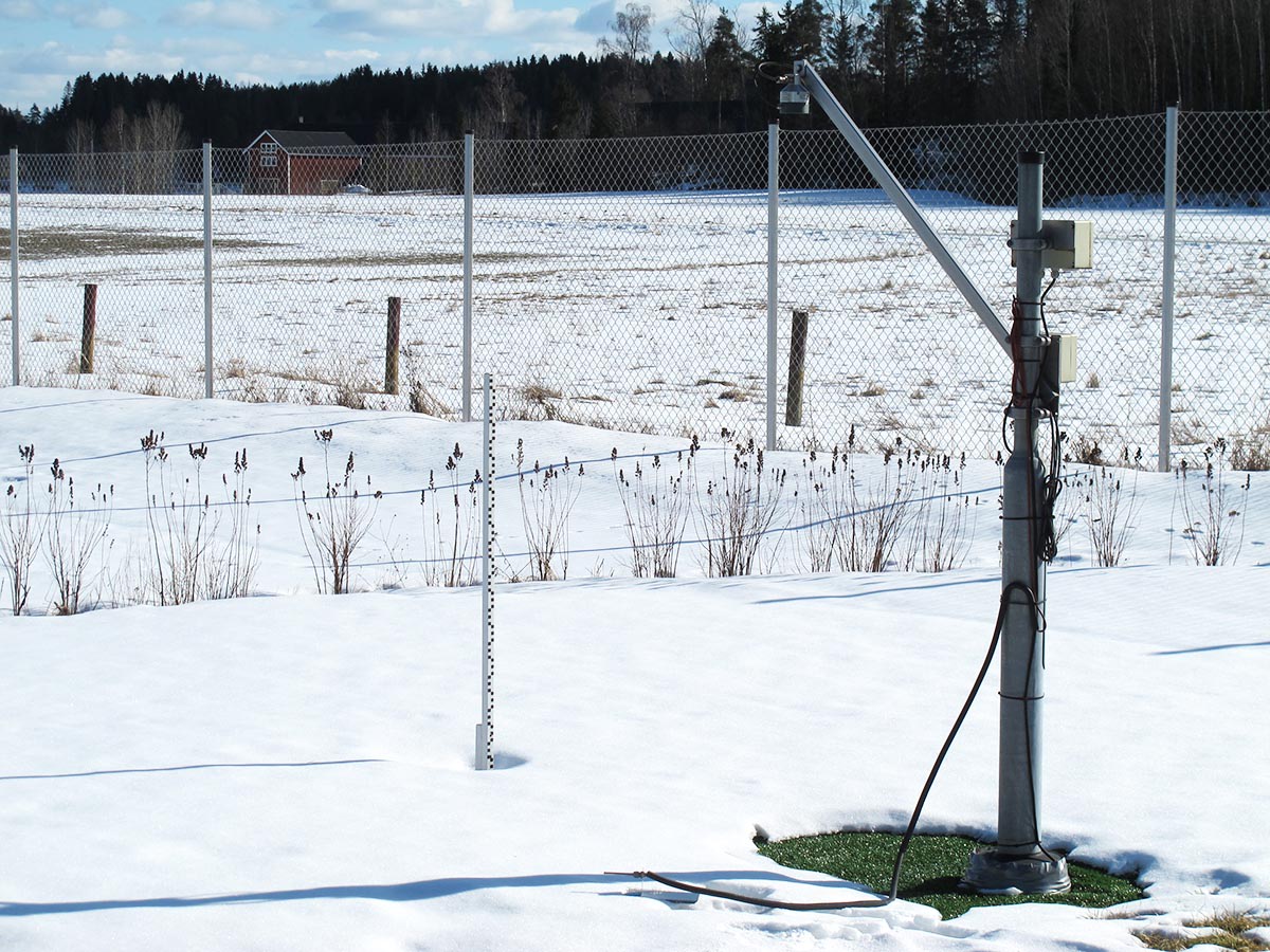 Lumikeppi ja automaattinen lumensyvyysmittari aidatulla havaintoasemalla.
