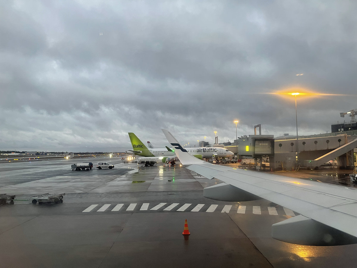 Kuva koneen ikkunasta lentokentälle koneen ollessa parkissa, sateisella säällä.