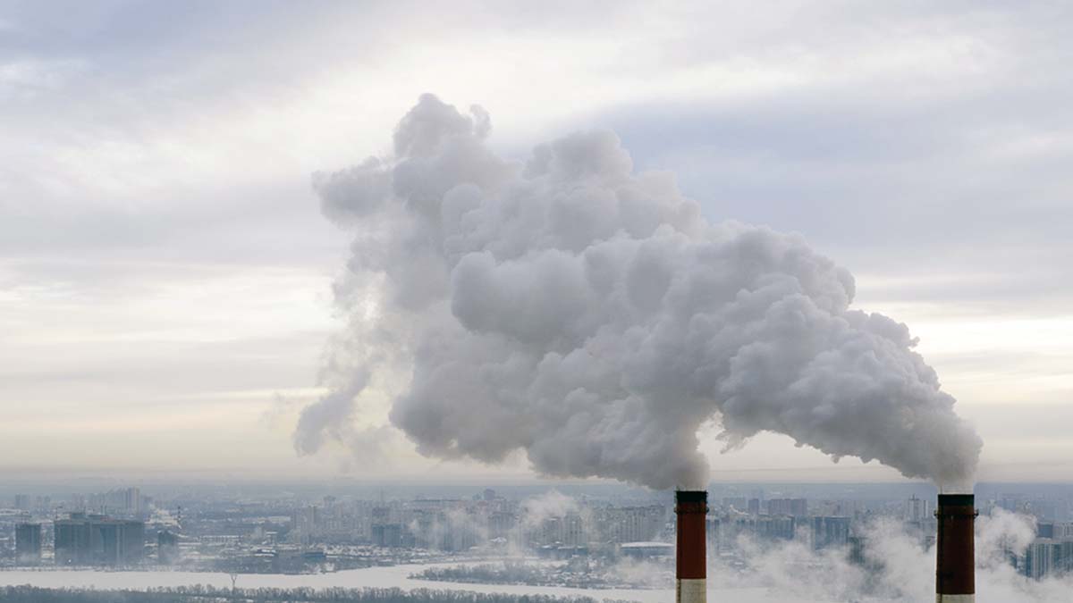 Kuvassa kaksi savupiippua, joista nousee savua.