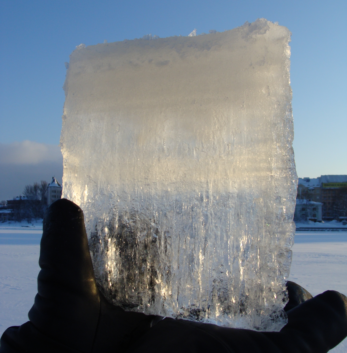 Jääpala aurinkoa vasten. Yläosa on vaalea ja alaosa läpinäkyvä.