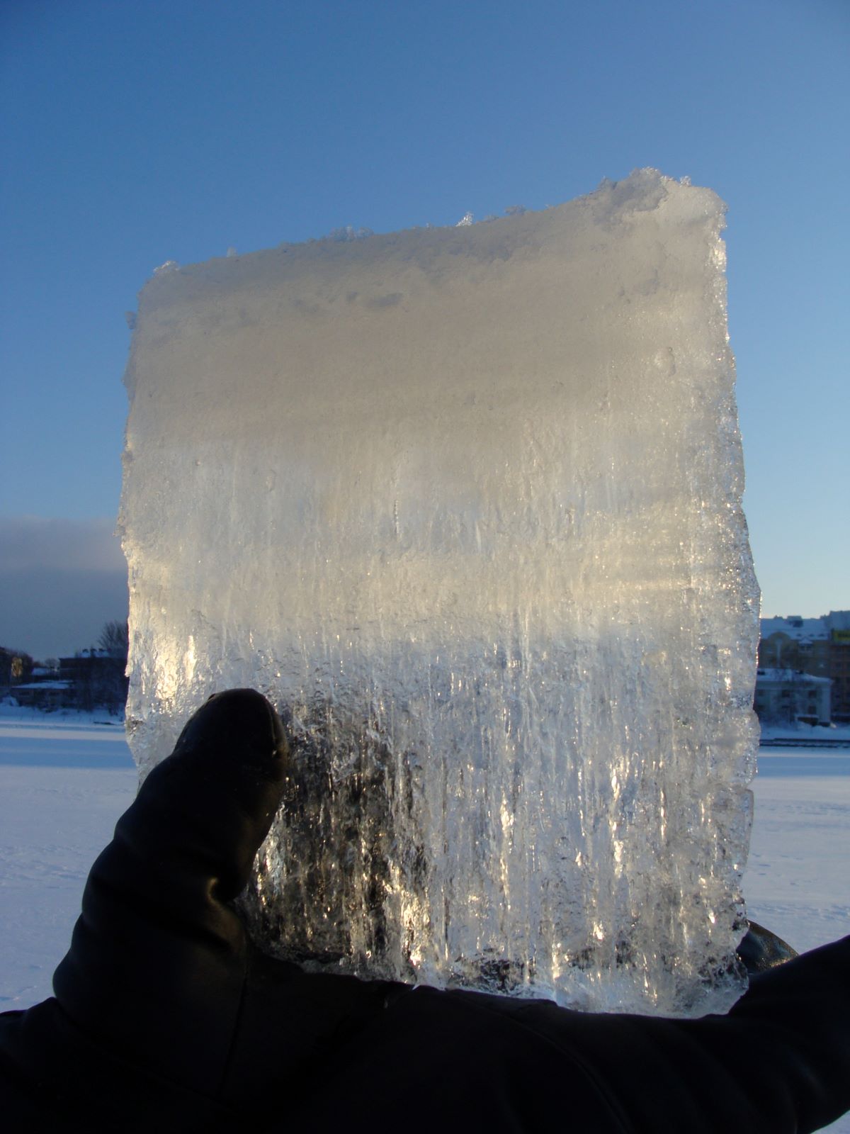Jääpala aurinkoa vasten. Yläosa on vaalea ja alaosa läpinäkyvä.