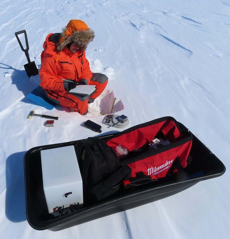 Leena tekemässä lumikuoppamittauksia jäätiköllä. 