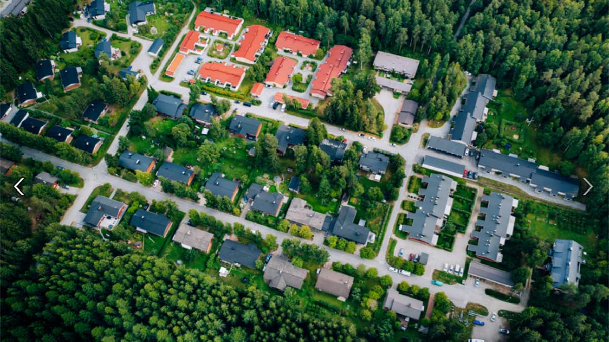 Ilmakuvassa pientalojen kattoja metsän ympäröimänä.