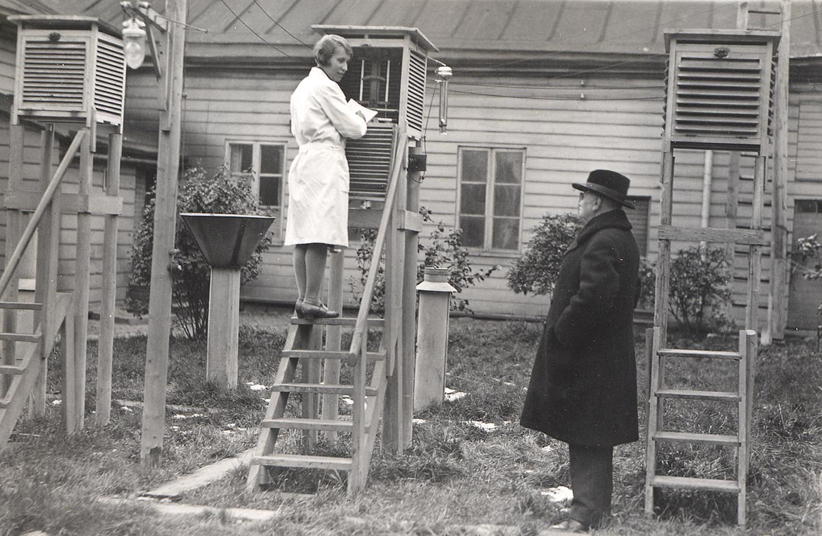 Havainnontekijä kiivennyt mittaamaan säähavaintoja vanhan säleikön sisällä olevasta mittarista. 