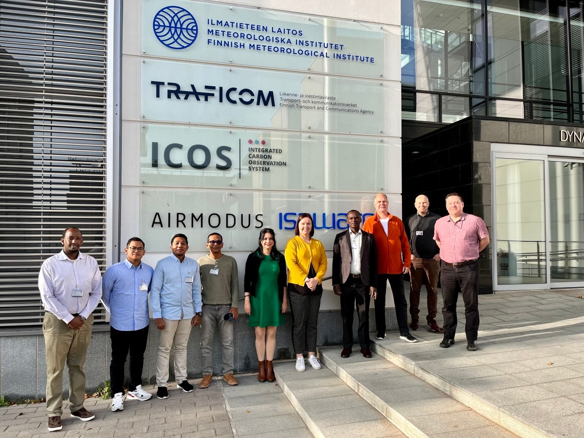 Kuvassa kymmenen ihmistä rivissä Ilmatieteen laitoksen Dynamicum-rakennuksen edustalla.