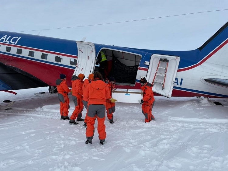 Retkikuntalaiset purkamassa rahtia Basler suksilentokoneesta. 