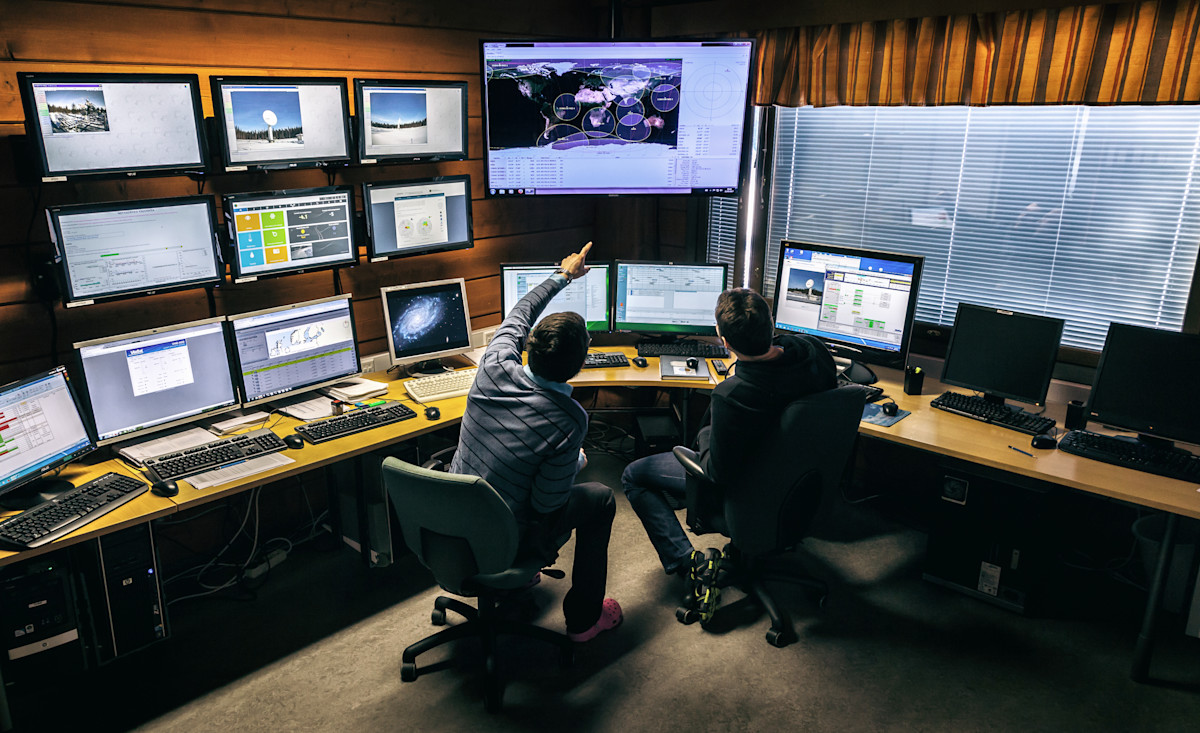 Kuvassa kaksi henkilö monitorien edessä. 