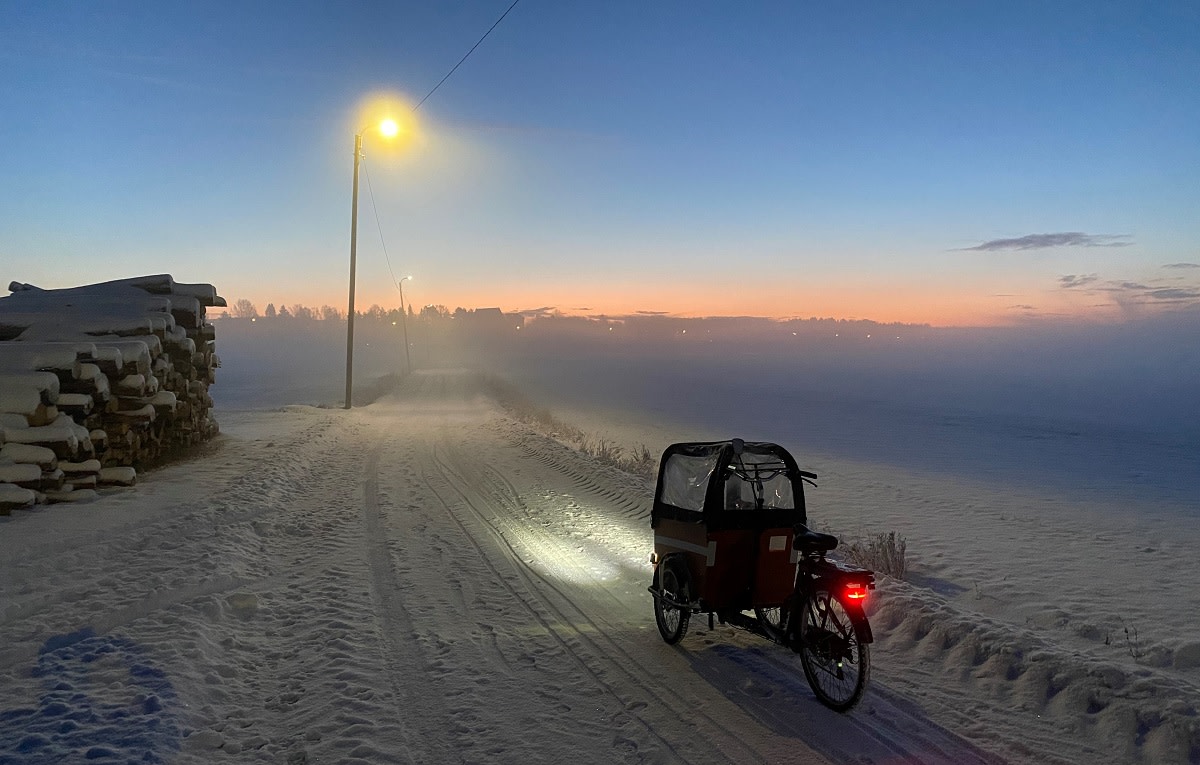 Kylmä talviaamu maaseudulla. Sumua ja polkupyörä sekä tukkipino.