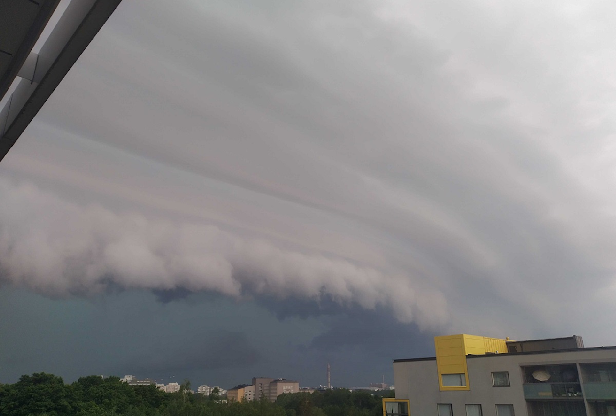 Etualalla pilvessä juovia, sitten pilvirulla ja sen takana hyvin tumma taivas, kun vettä sataa paljon. Hyvin synkkä tunnelma.