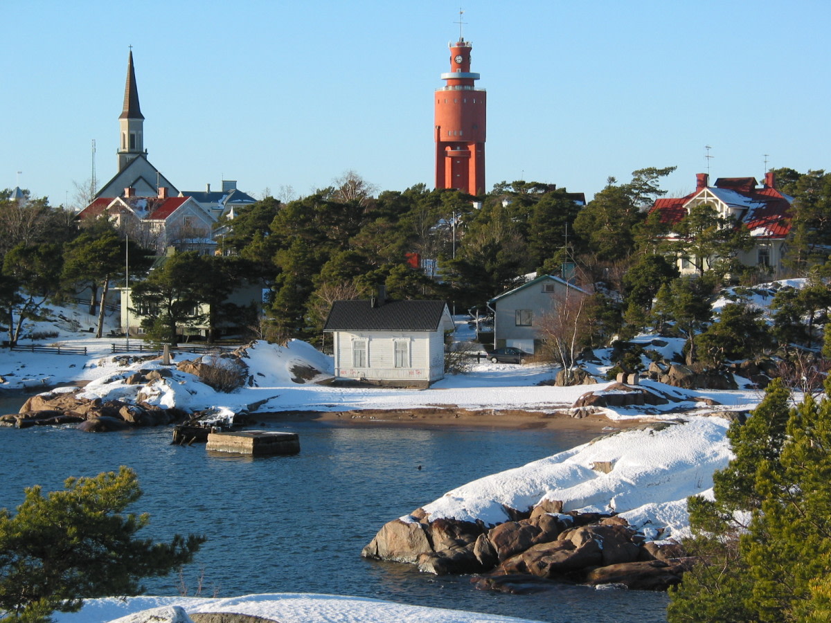 Lahdessa avovettä, rannoilla lunta ja rakennuksia.