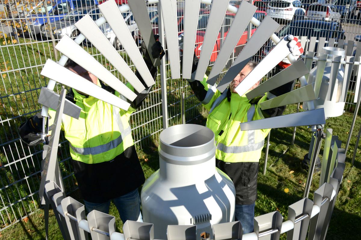 Kaksi työntekijää huoltamassa säähavaintoasemaa.