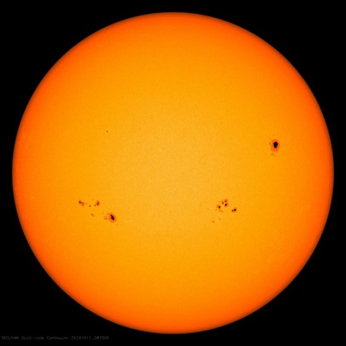Aurinko, jossa musta pilkku oikealla reunalla.