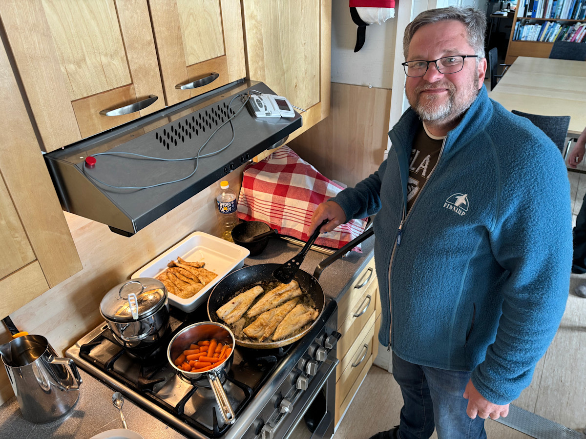 Kokki lieden ääressä, jossa valmistumassa ruokaa retkikunnalle.