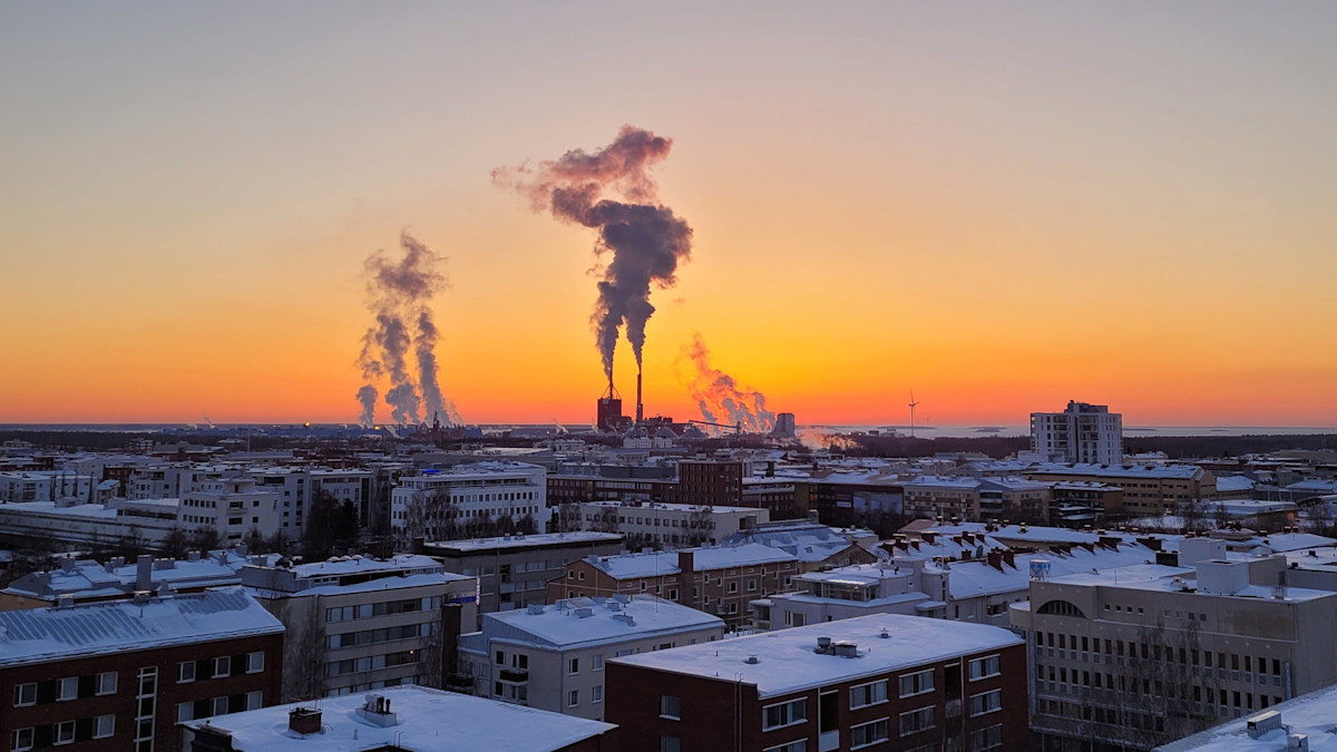 Kaupunkinäkymässä savupiipuista nouseva savu ei nouse tiettyä korkeutta korkeammalle inversiotilanteesta johtuen.