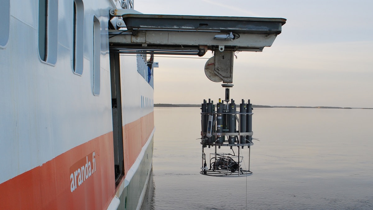 Laivan kyljen luukusta lasketaan isoa CTD-laitetta mereen.