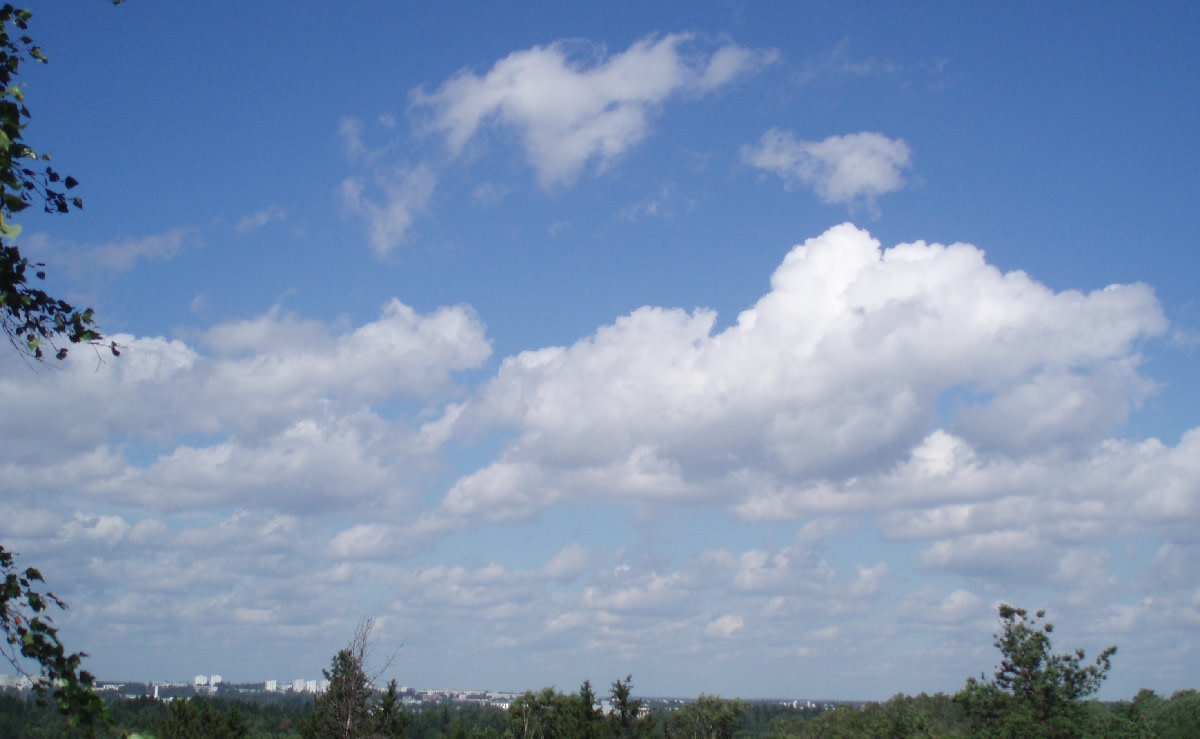Sinisellä taivaalla on vaaleita kumpupilviä, mutta silti on aurinkoista.