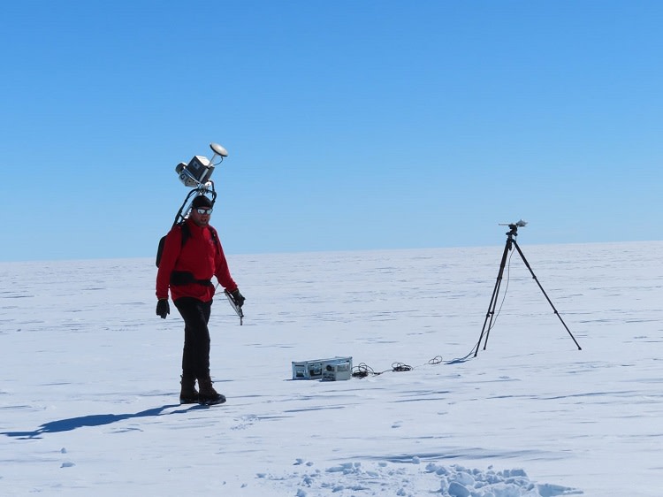 Antero tekee laserkeilausta reppuun asennetun laserin avulla. Takana siirrettävä säteilyasema, joka mittaa tulevaa säteilyä ja lumesta heijastuvaa säteilyä.