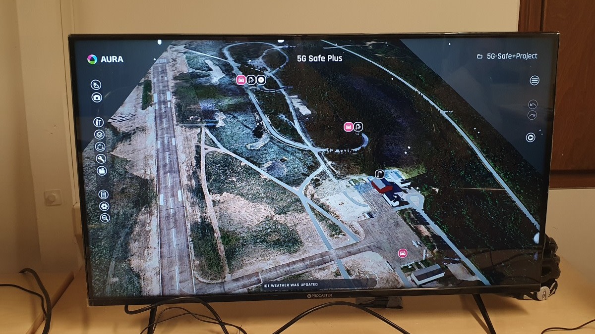 Tietokoneen näytöllä näkyy testirata ilmakuvassa, ajoneuvojen sijainnit ja varoitukset.