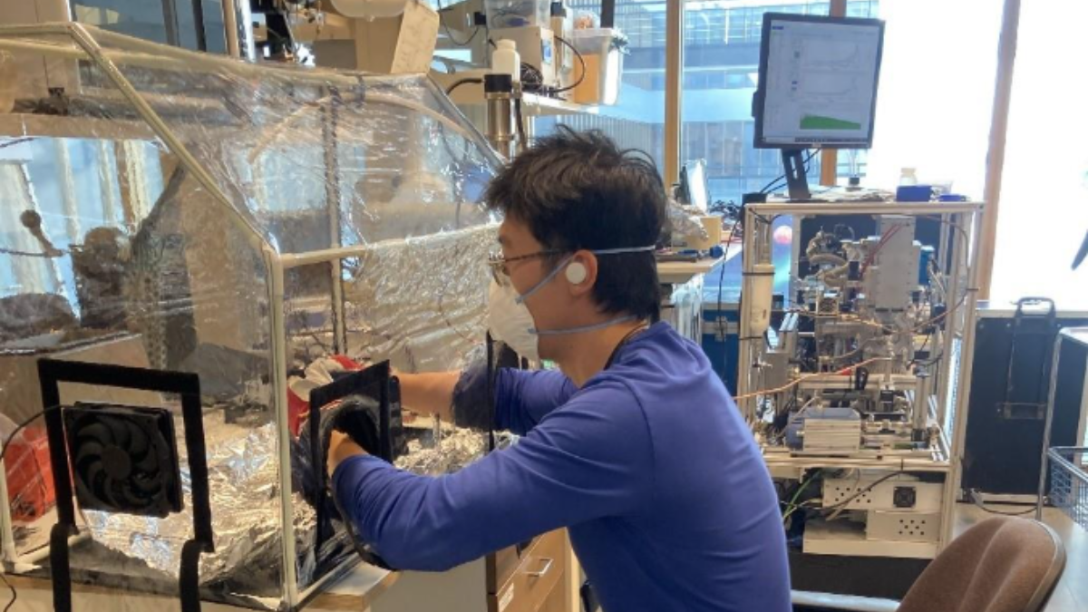 Kuvassa tutkija Delun Li istuu työtuolissaan laboratoriossa ja tuottaa hiukkasia autonrenkaasta.